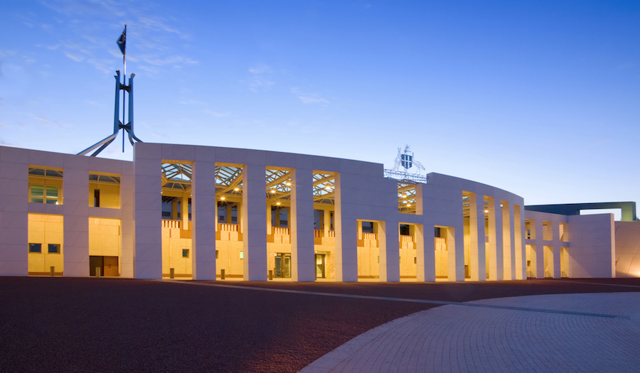 Australian Parliament House illuminated at twilight. Slight motion blur on flag due to long exposure.