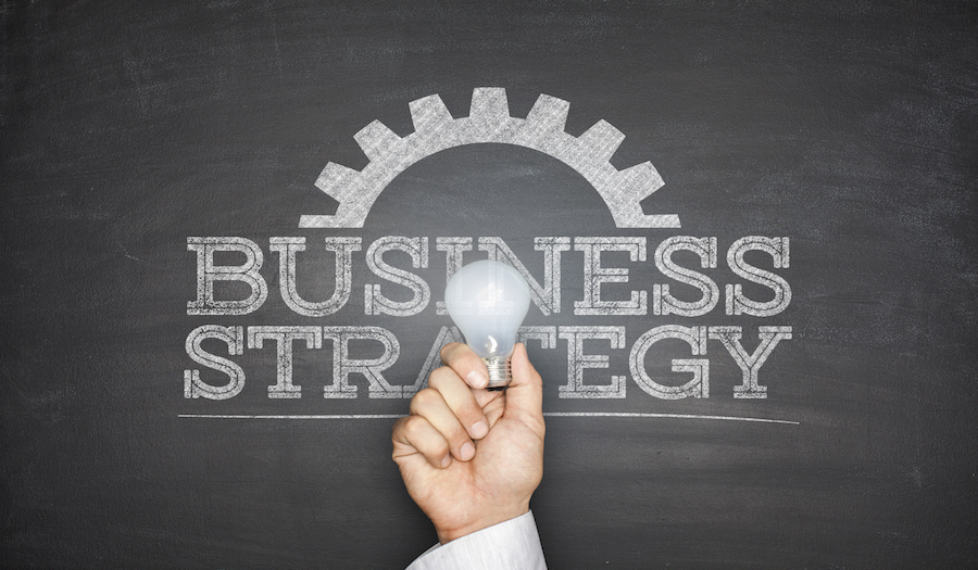 Business strategy concept on blackboard with light bulb