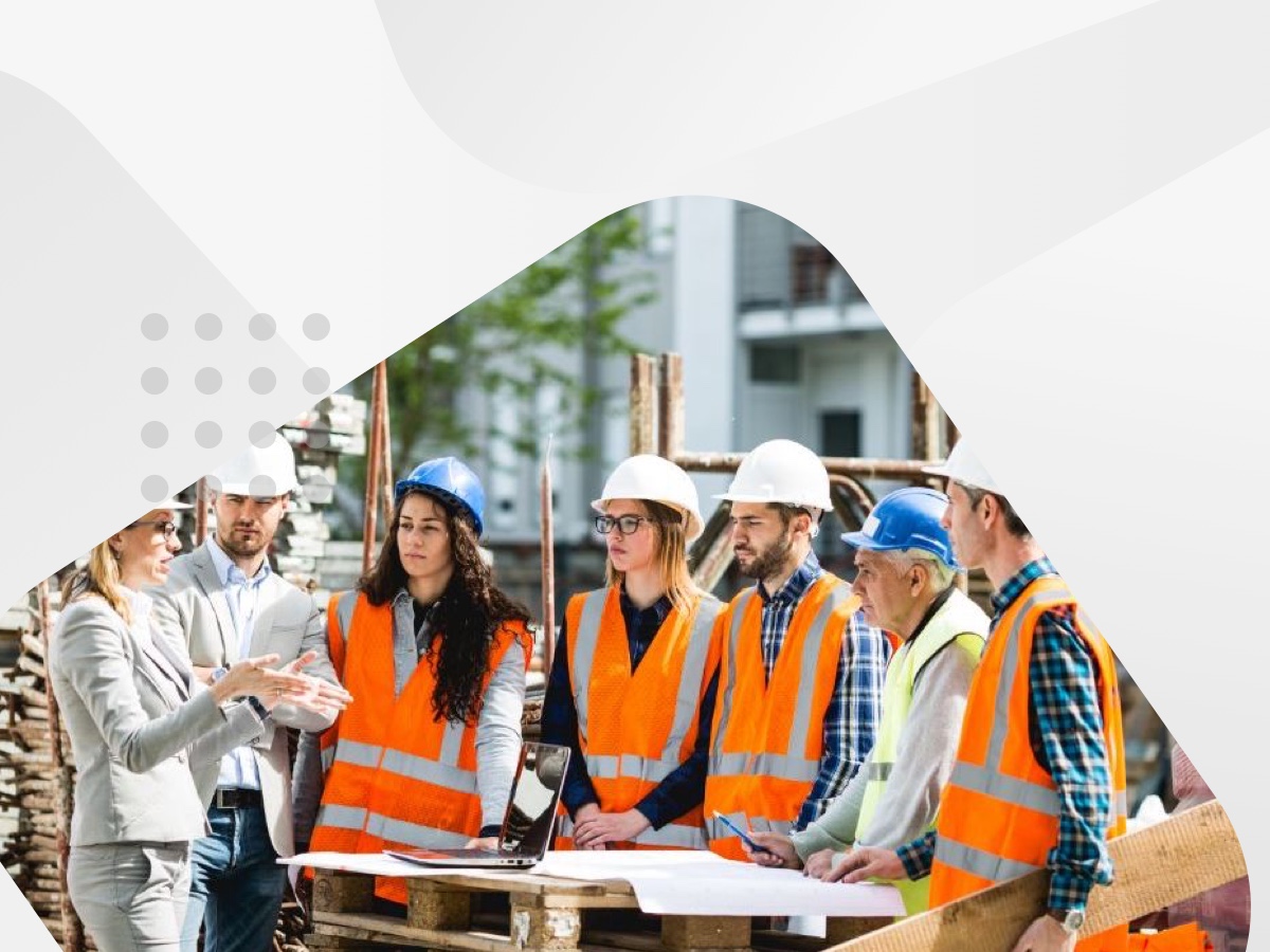 A diverse group of individuals wearing construction vests and hard hats, working together on a construction site.