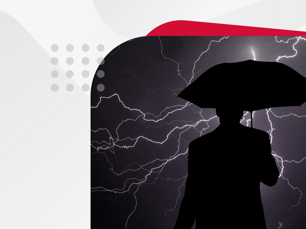 A man in a suit holding an umbrella, shielding himself from a lightning storm.
