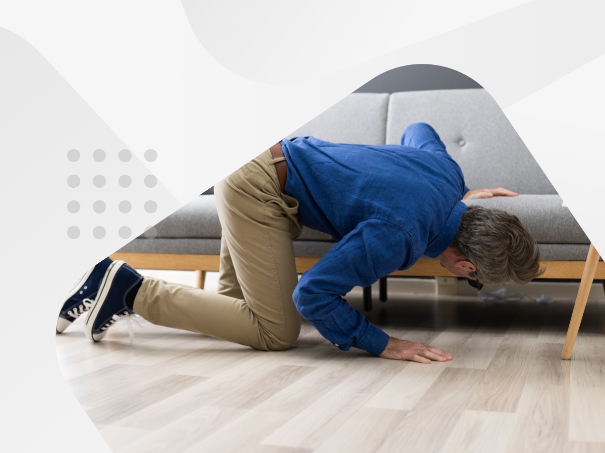 Man looking under couch